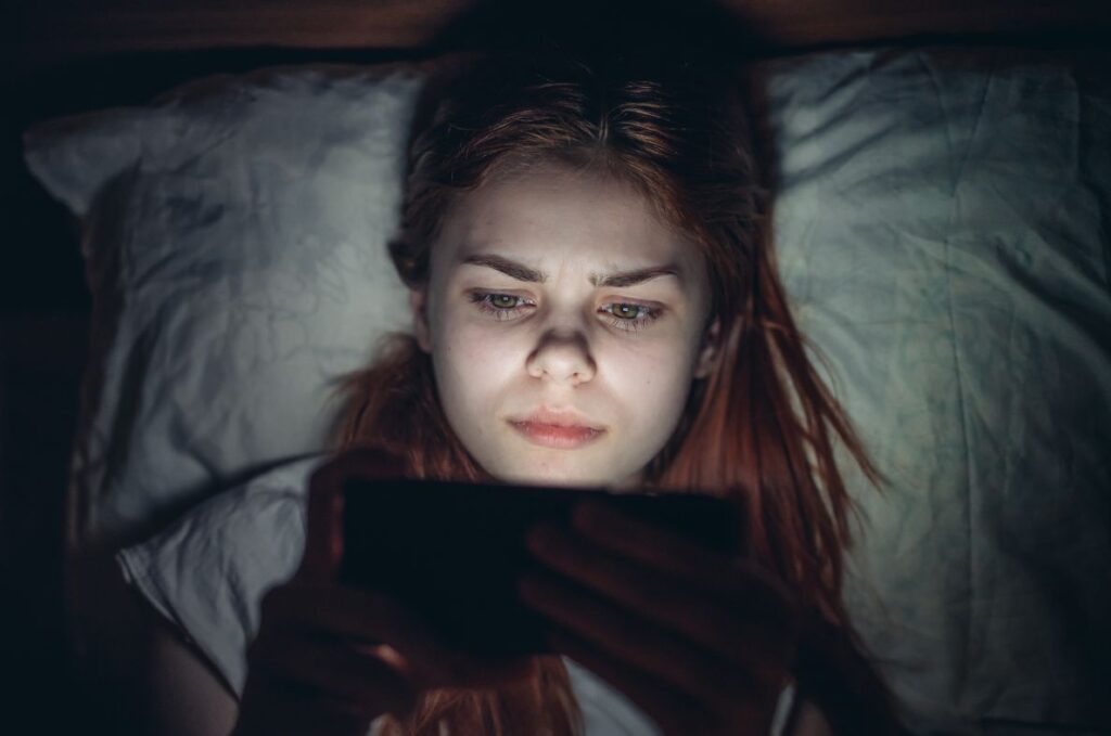 Une femme qui regarde un écran avant de dormir